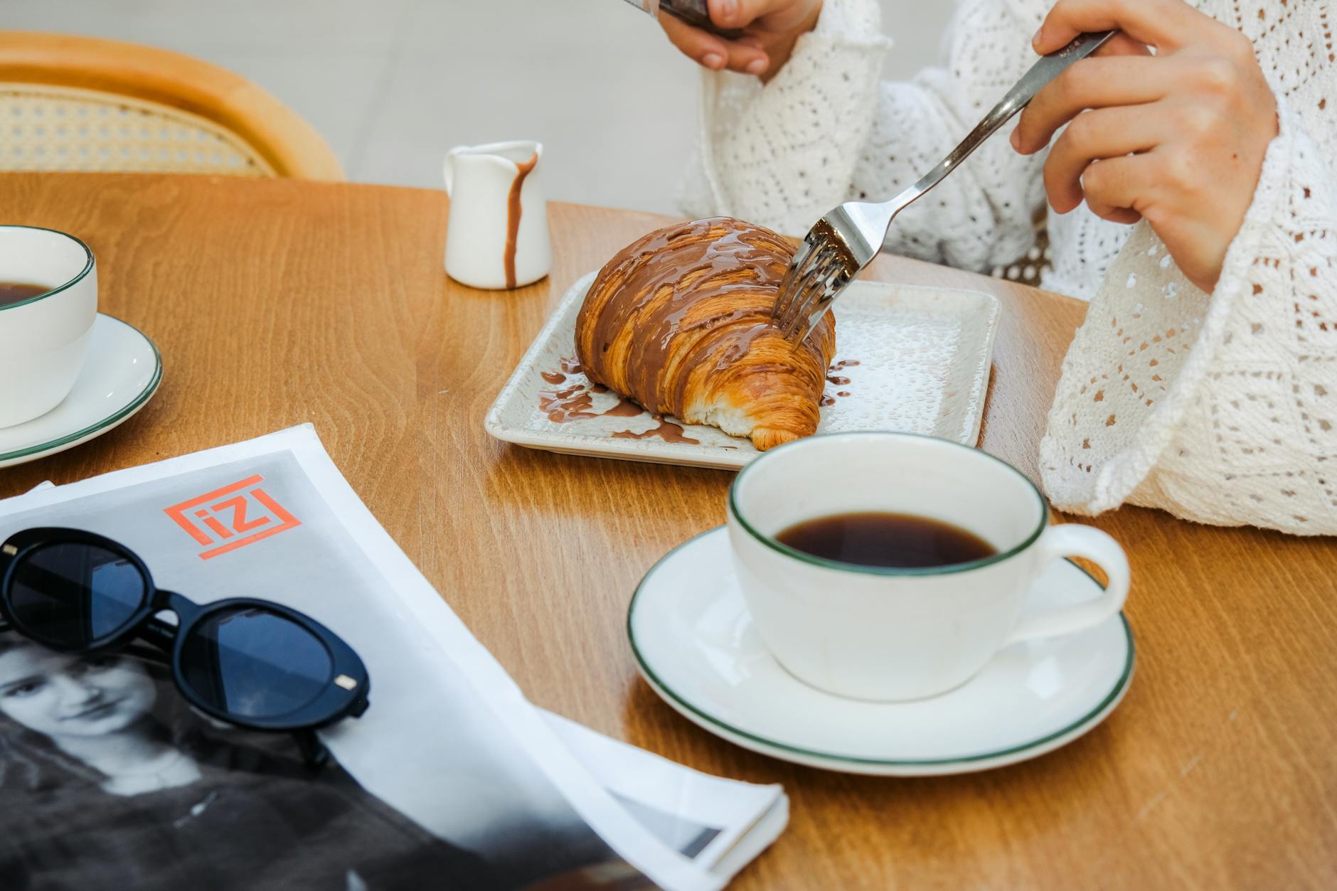 Kawa i czekoladowy croissant na śniadanie w krakowskiej kawiarni