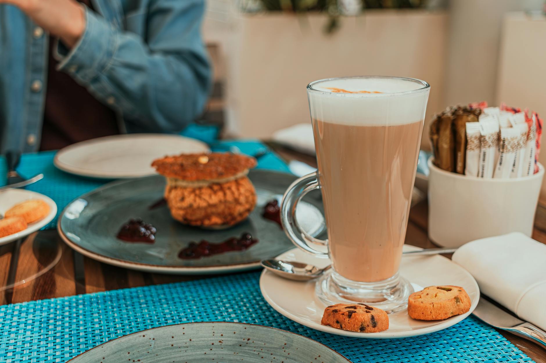 Latte i słodkie wypieki na jasnym stoliku w przytulnej kawiarni