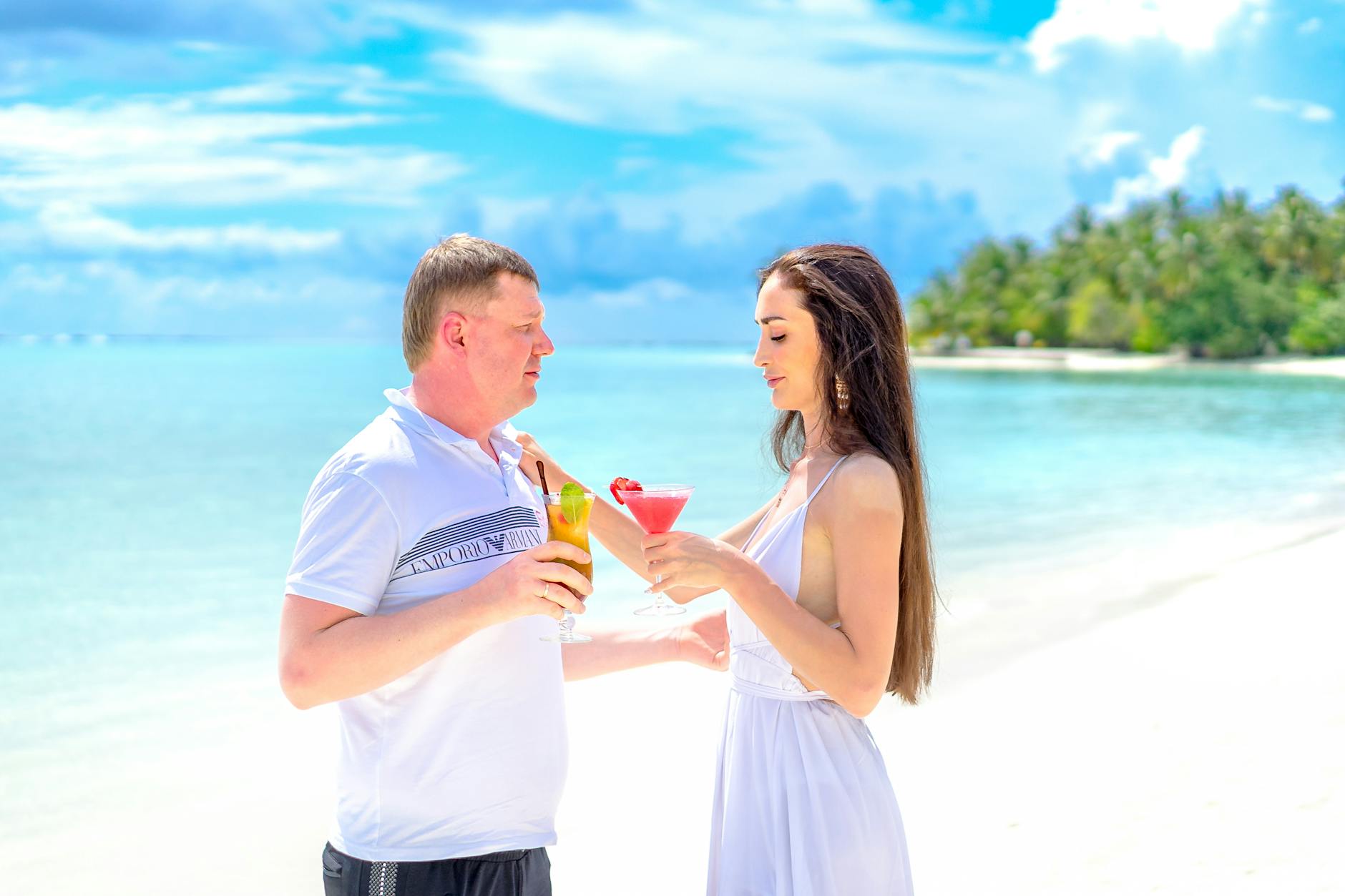 Para z drinkami na tropikalnej plaży w romantycznej atmosferze