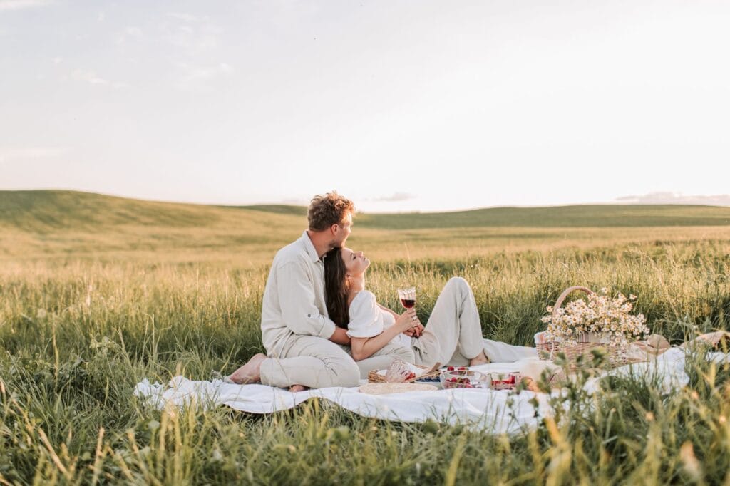 Para podczas romantycznego pikniku na słonecznej łące